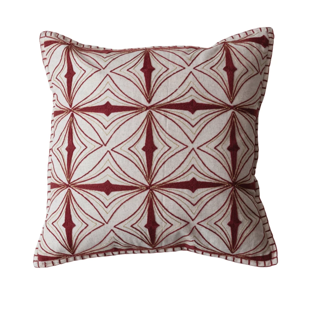 This square pillow is a showcase of craftsmanship, with its beautiful embroidery in metallic gold thread creating a captivating pattern. The natural and burgundy color palette brings warmth and depth, while the blanket stitch edge adds a handcrafted touch.