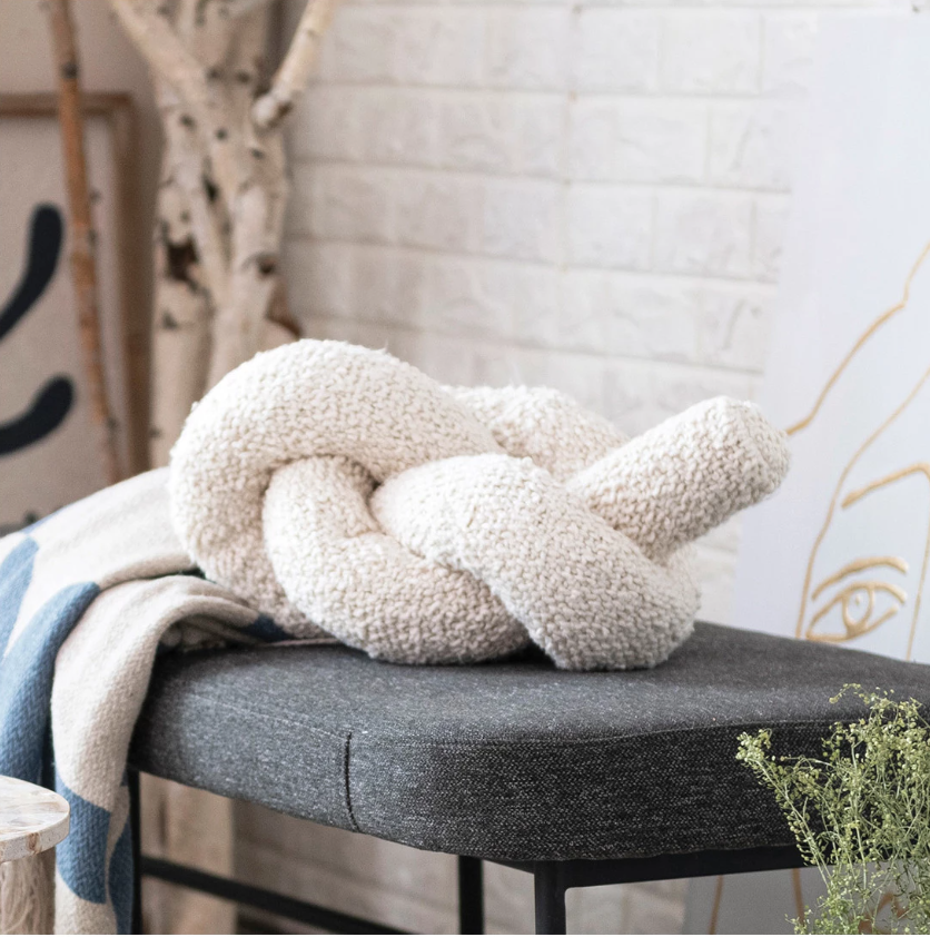Enhance the home decor with this woven cotton bouclé knot pillow in cream. This pillow features a woven cotton bouclé fabric that creates a soft and cozy feel. The bouclé material is textured and curly, giving the pillow a unique and charming look. The cream color is neutral and elegant and can match any color scheme or theme.