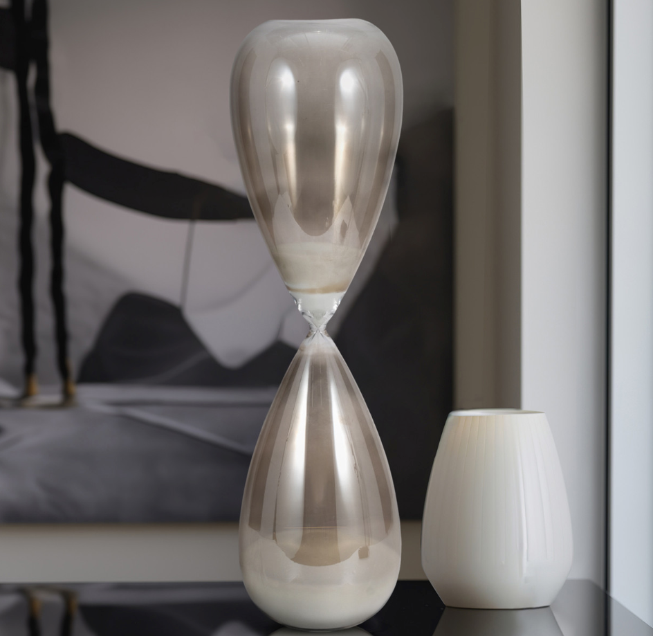 Introducing the&nbsp;23" Galene Large Grey Hourglass, a stunning fusion of elegance and functionality that will elevate the aesthetic of any casual home decor. This exquisite piece, crafted entirely from high-quality glass, showcases a sleek and modern design that seamlessly fits into a variety of interior styles.