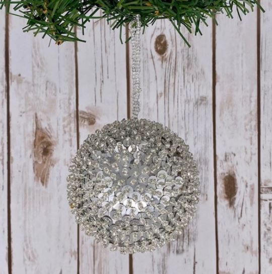 Add a touch of sparkle to your holiday decor with our 4" Sequin Beaded Ball Ornament in Silver. This dazzling ornament is beautifully adorned with shimmering sequins and beads, catching the light and creating a stunning effect on your Christmas tree.