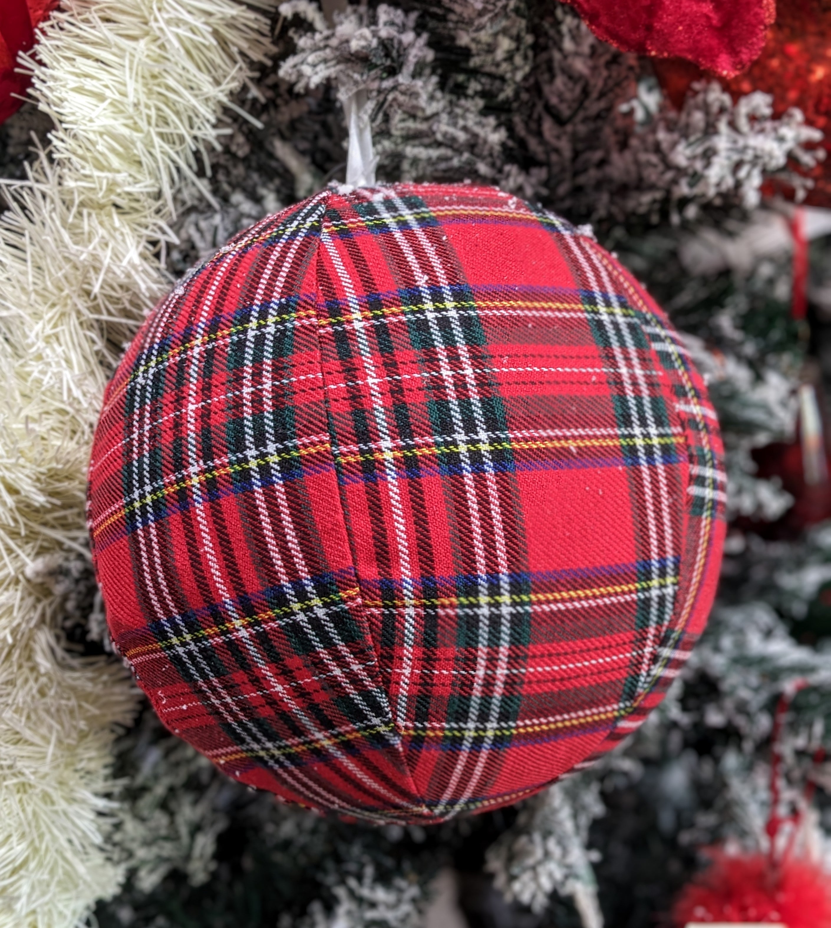 Embrace the festive spirit with our 8" Large Red and Green Plaid Ball Hanging Ornament. This stunning ornament features a bold plaid design, combining vibrant reds and greens that instantly add a cozy, traditional touch to your decor.