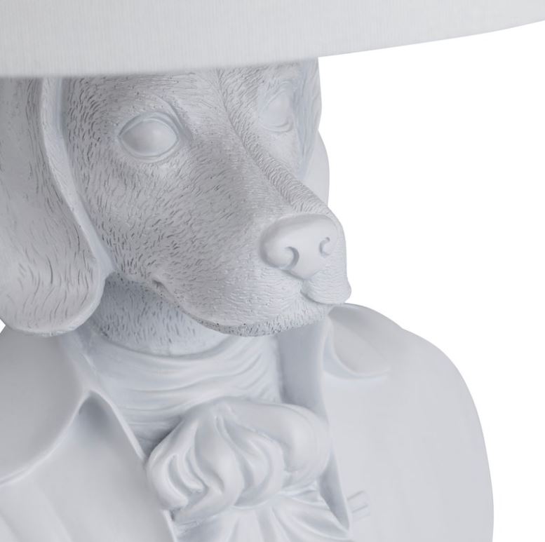 Add a touch of whimsy to your space with the Beauchamp Table Lamp, featuring a charming dog bust dressed in formal attire with a matte white finish. The crisp white linen shade enhances its playful yet sophisticated appeal. Perfect for adding a unique and delightful accent to any room.