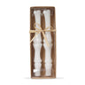 A set of two white bone-colored taper candles packaged in a clear box.
