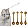 A set of four brass spoons with mushroom-shaped handles, displayed alongside a printed drawstring bag with the illustration of the spoons.