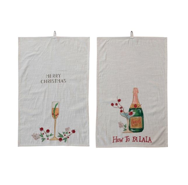 This set of two cotton slub printed tea towels features a festive and fun touch to the kitchen. The towels have a rectangle shape and a slub texture, giving them a casual and cozy feel. They come in two styles, each with a different holiday cocktail, saying, and loop in multicolor, with sayings like "Merry Christmas" and "How to Falala".