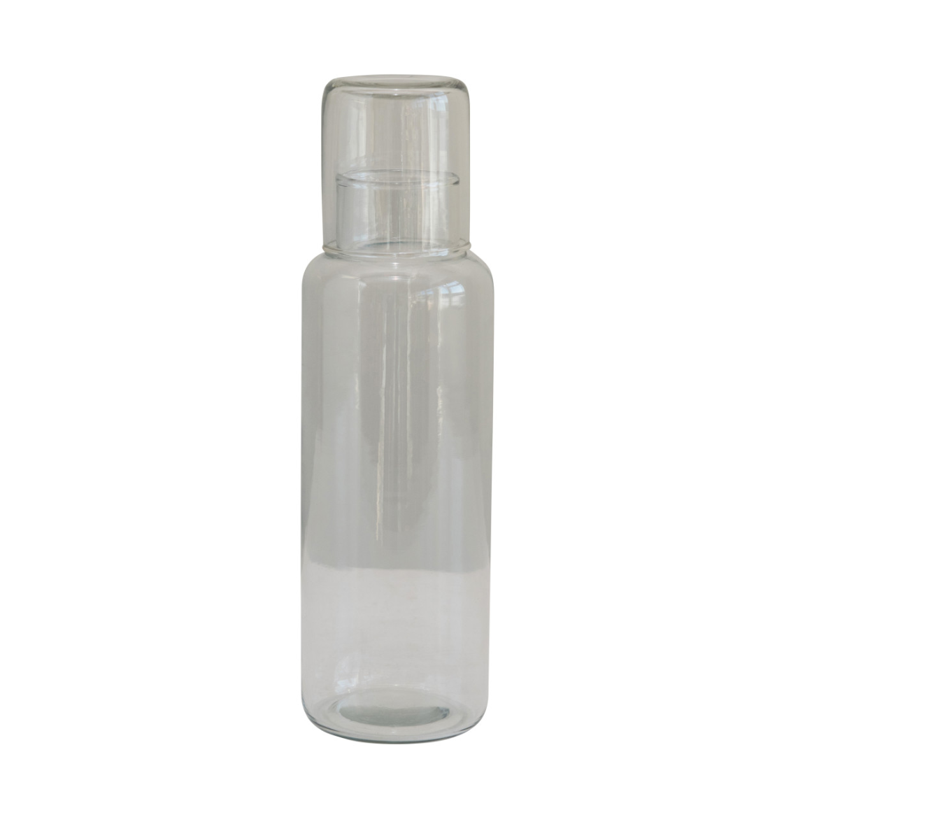 A clear glass decanter with a matching drinking glass, both are empty and set against a white background.