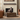 Modern living room with a fireplace, decorative vases on a wooden table, and brown armchairs.
