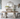 Dining room with ornate table and chairs, decorative mirror, and floral arrangements.