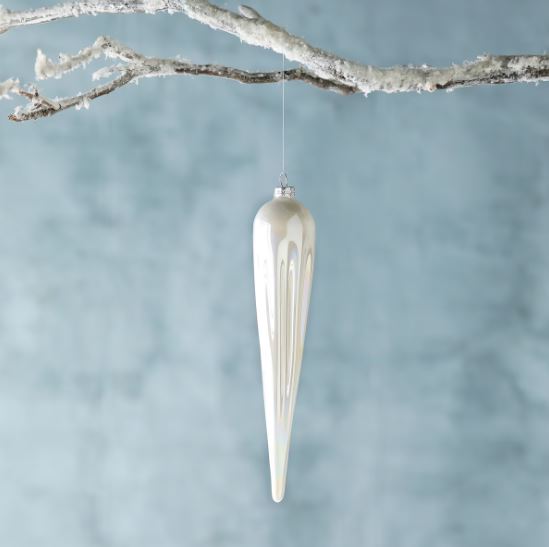 Our Frosty Pearl Glass Icicle Ornament is a dramatically elongated bauble at 10” in length with a pearlescent hand finish that adds glisten and shine to their milky white color. The statement ornament is a perfect way to add a whimsical touch to frosty themed décor.