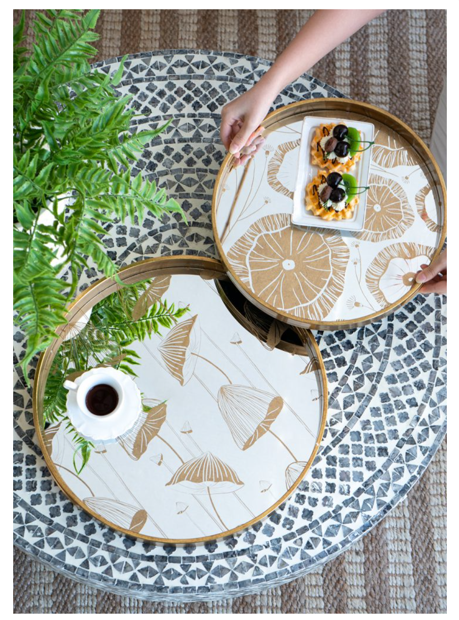 A pair of round plastic trays with a gold rim and floral motifs in the center.