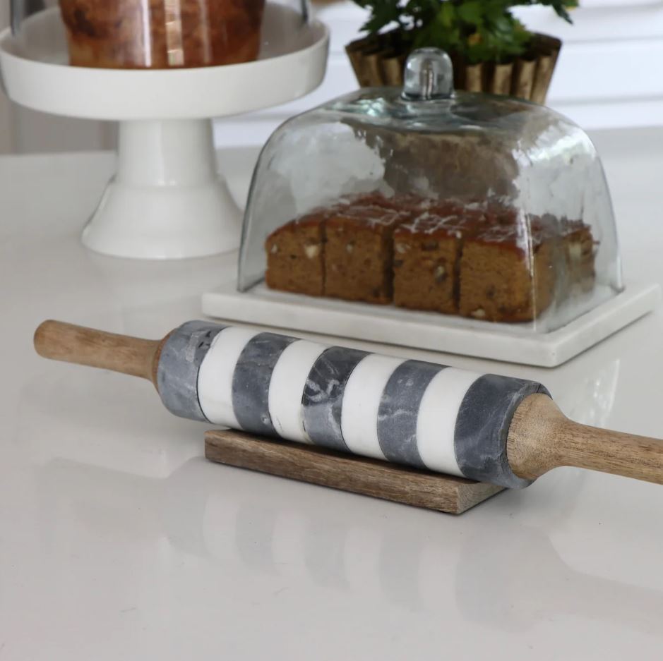 A marble-striped rolling pin with a wooden handle and a striped pattern running through the center of the rolling part.