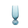 A blue pleated footed champagne glass against a white background.