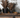 Two potted plants on a wooden tray with a textured wall in the background