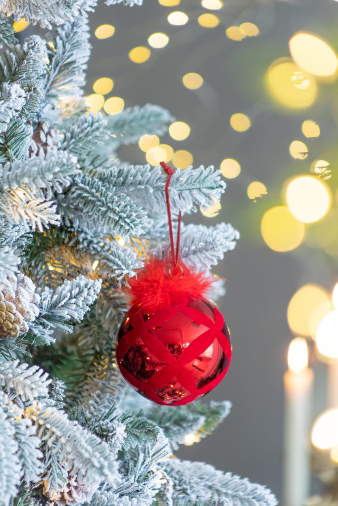 Add a touch of elegance to your holiday decor with our Red Glass Christmas Ball Ornament adorned with feathers. This stunning ornament features a rich red hue with a glossy finish, beautifully complemented by delicate, soft feathers that create a luxurious look.