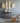 Decorative wall art pieces on a gray wall with a wooden table and chair in the foreground.