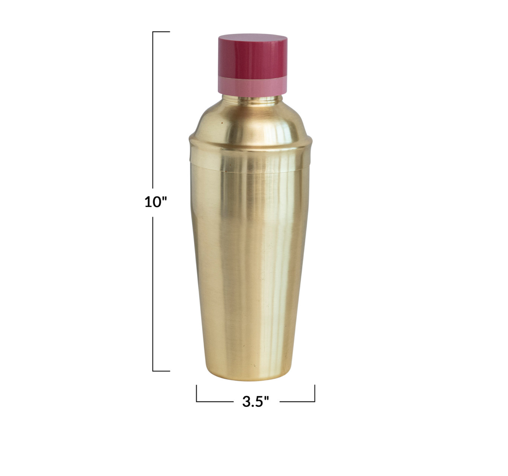  A gold stainless steel cocktail shaker with a two-tone red and beige resin lid.
