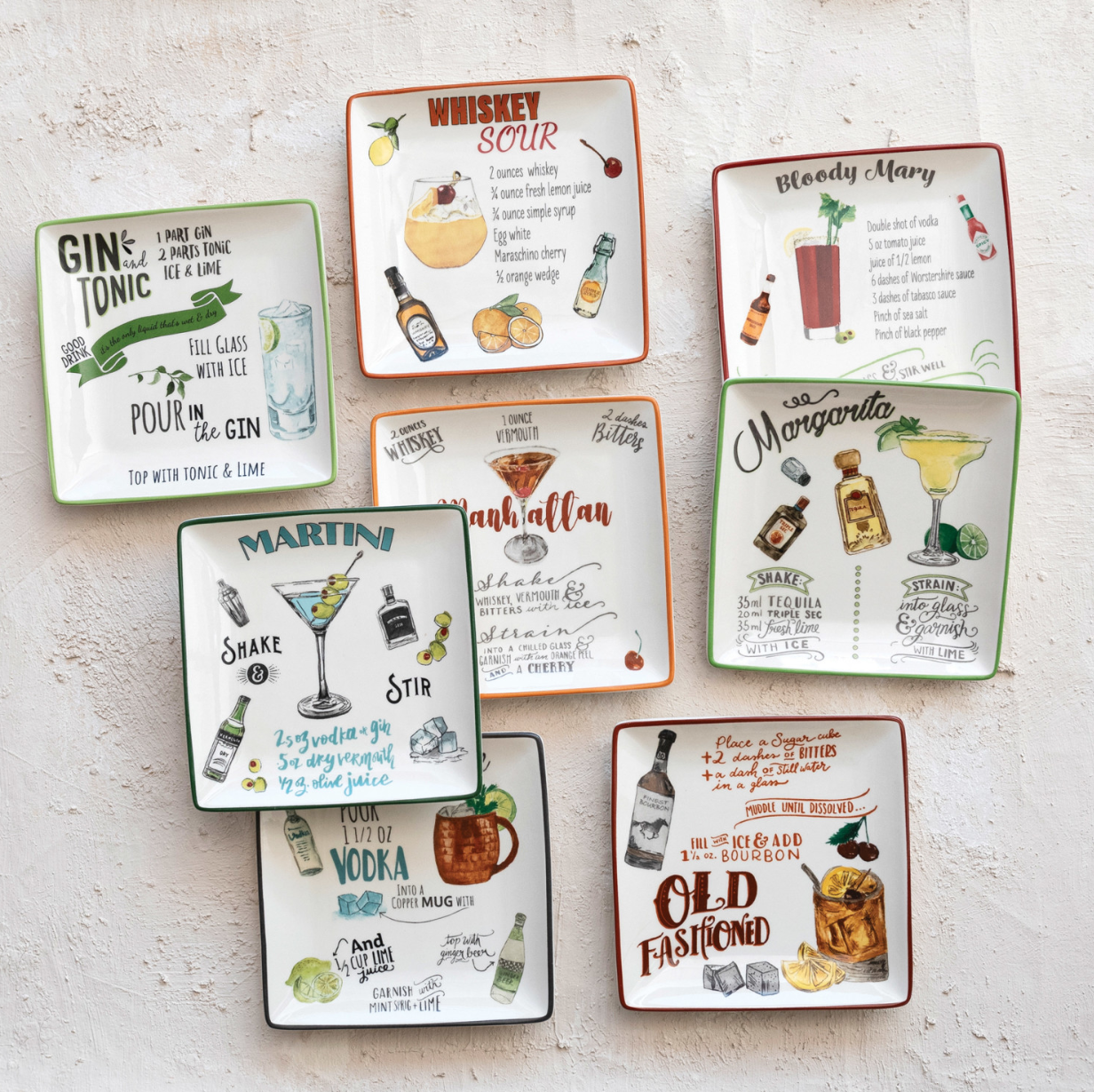 A collection of stoneware plates each with a different cocktail recipe and artistic design.
