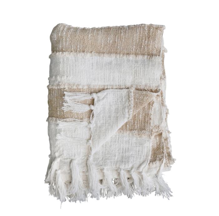 Add comfort and style to the home with this cotton throw with stripes and fringe in tan and natural. This throw blanket features soft cotton that creates a cozy and inviting feel. The woven stripes add some texture and detail to the simple design. The fringe adds some flair and movement to the edges of the throw. The tan and natural color is neutral and earthy and can match any color scheme or theme. This throw blanket is ideal for displaying in a living space of any style, from Scandinavian to farmhouse. 