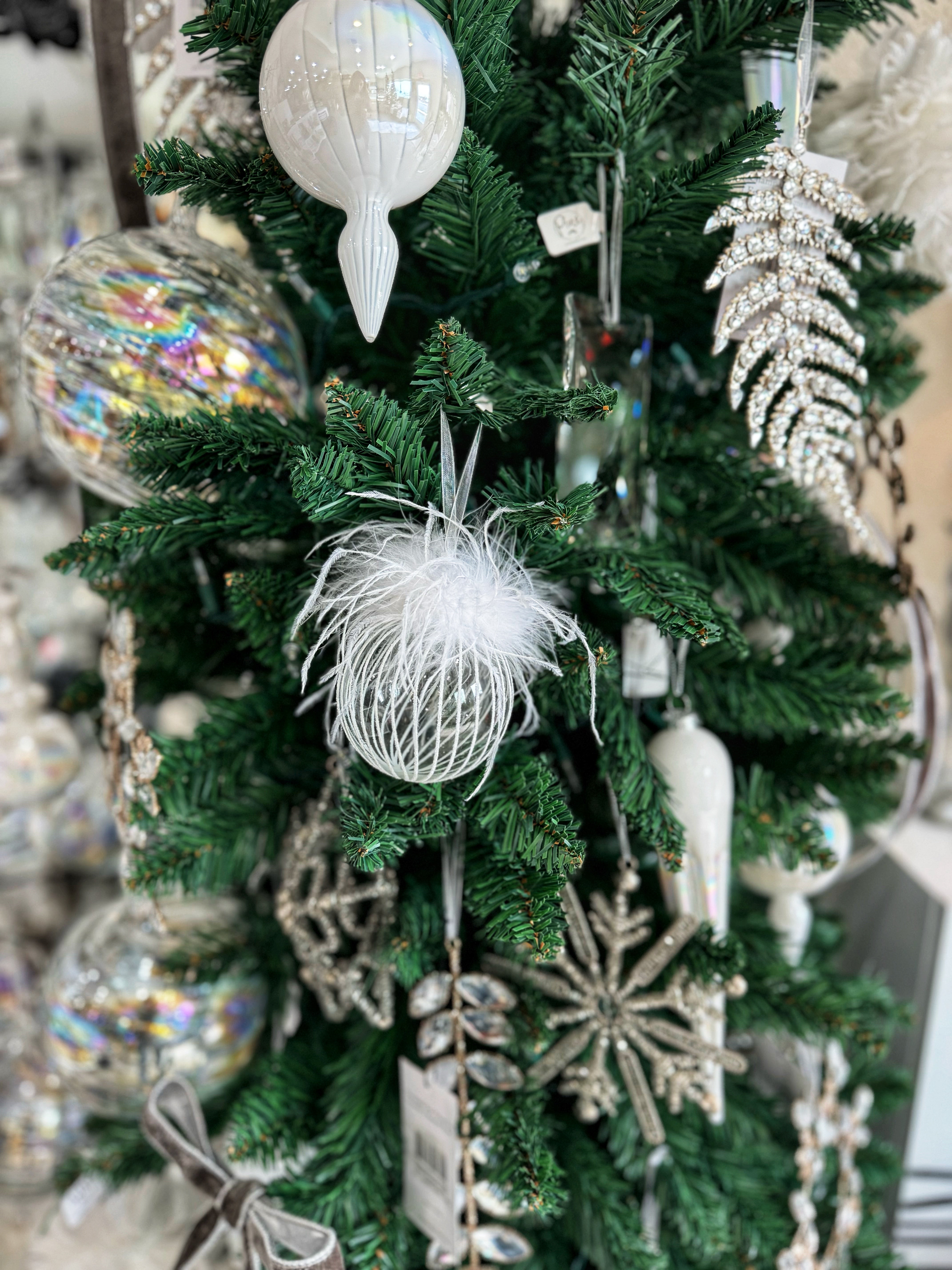 This exquisite ornament combines the elegance of glass with soft feathers, creating a stunning visual piece that catches the light beautifully. The clear and white color palette adds a touch of sophistication, making it perfect for both traditional and modern decor styles. Ideal for hanging on your Christmas tree or incorporating into seasonal displays, this ornament brings a unique and whimsical charm to your festive celebrations!